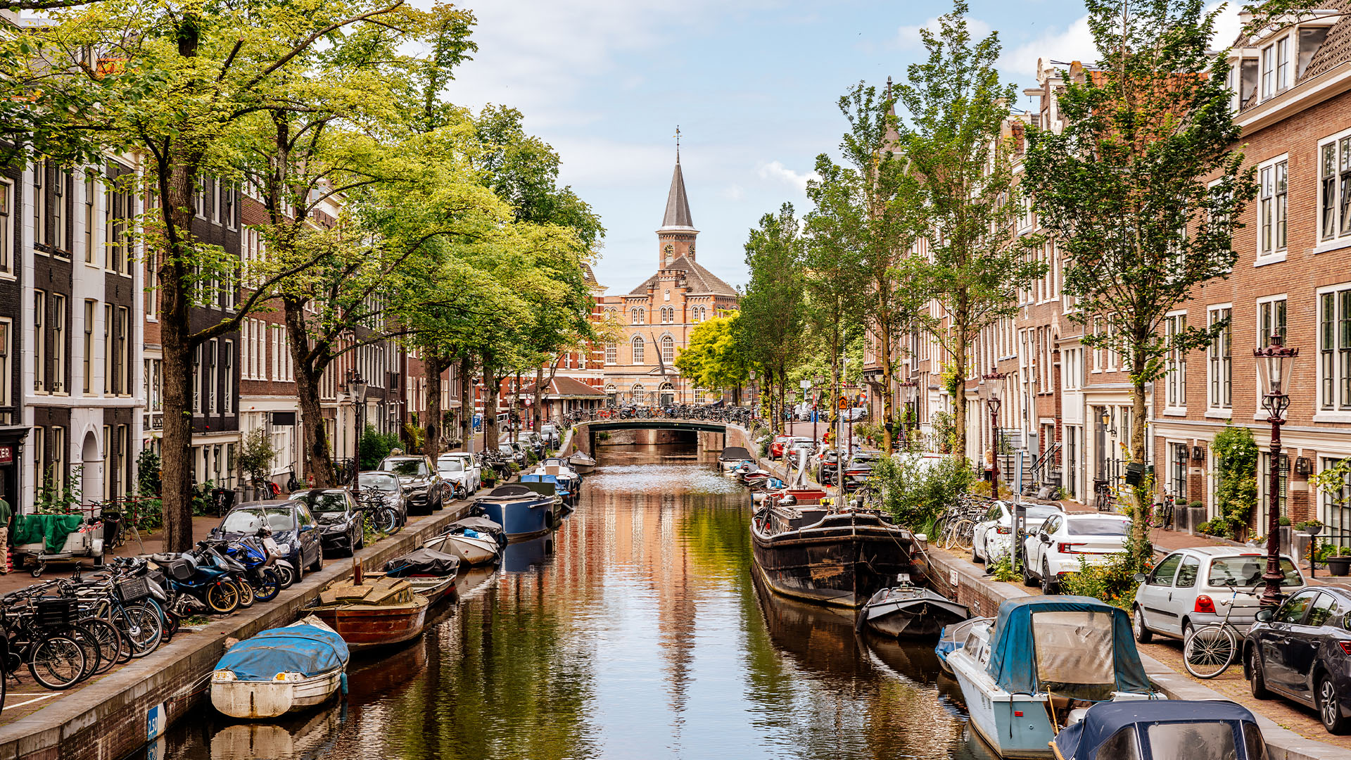 Canal lined with small boats in Amsterdam