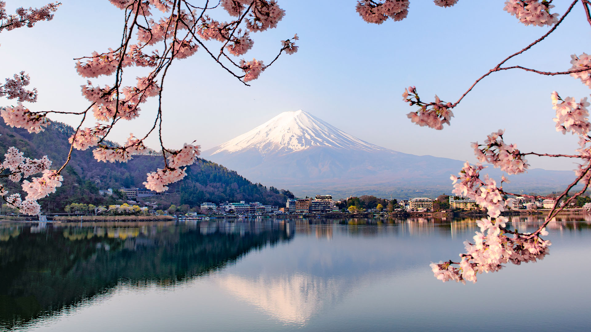Snowy peak of Mount Fuji reflected in a still lake