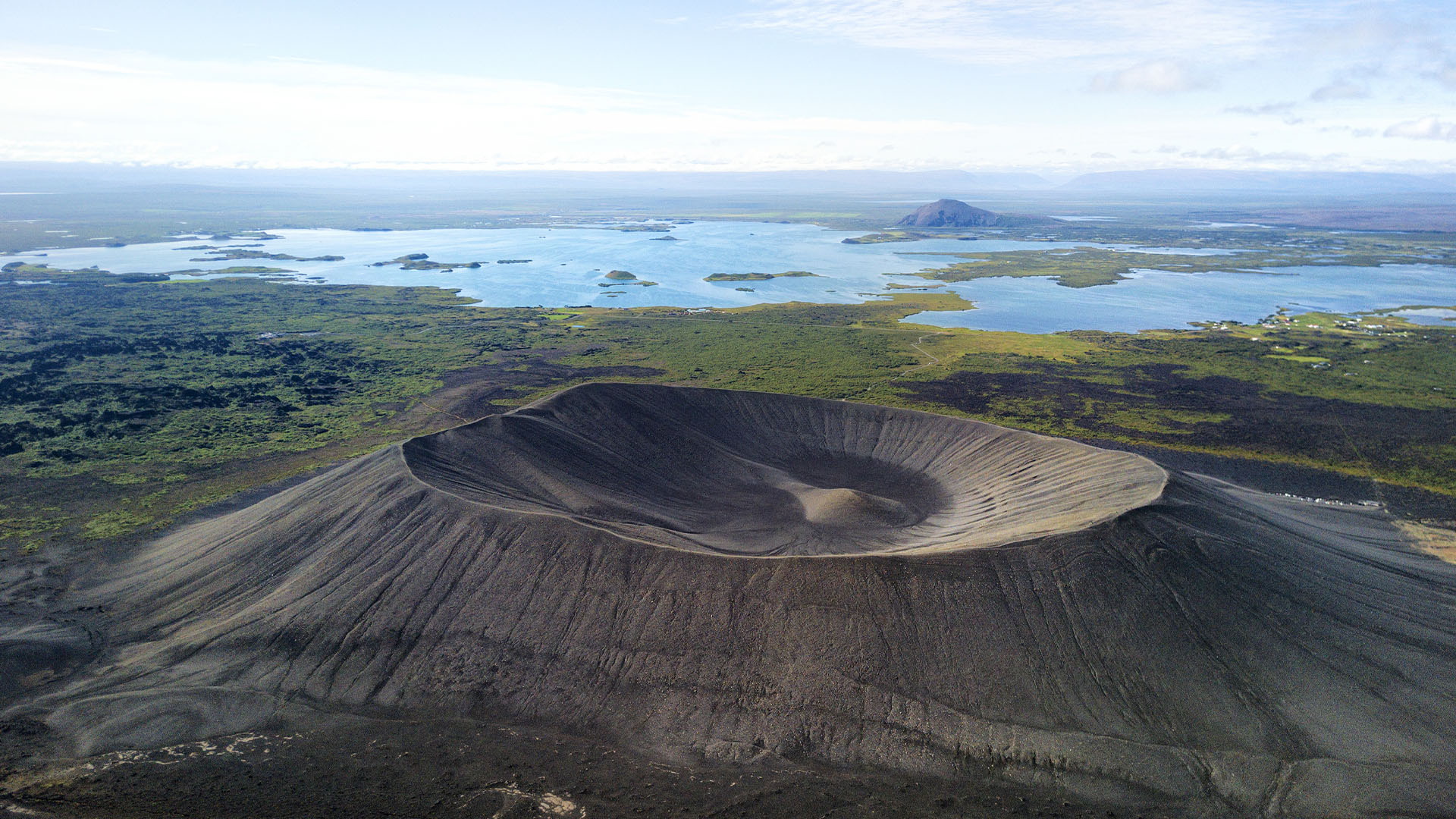 Volcanic crater surrounded by lakes and lava fields