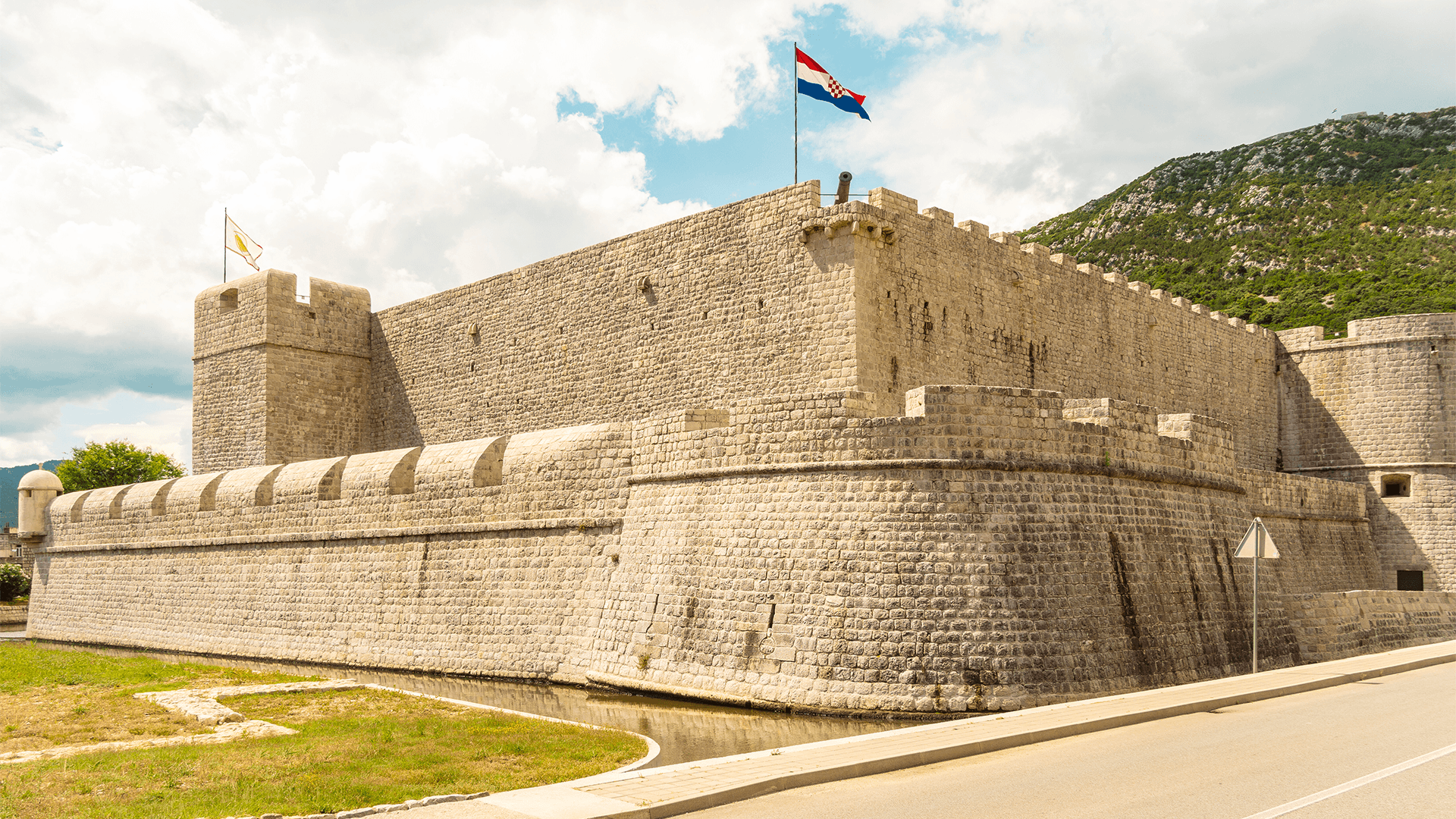 Stone fortress walls in Ston with Croatian flag