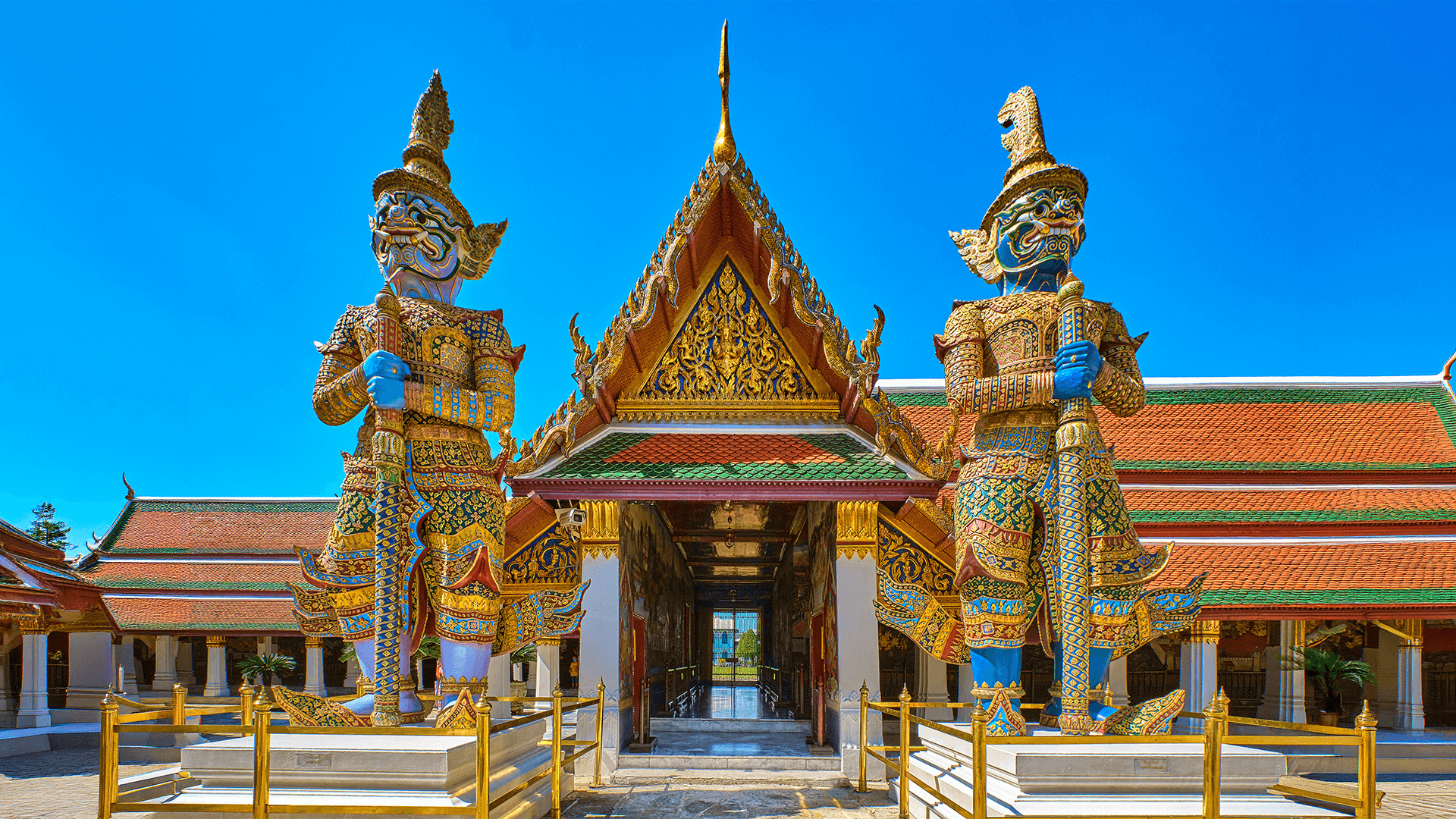 Ornate guardian statues at a Thai temple entrance