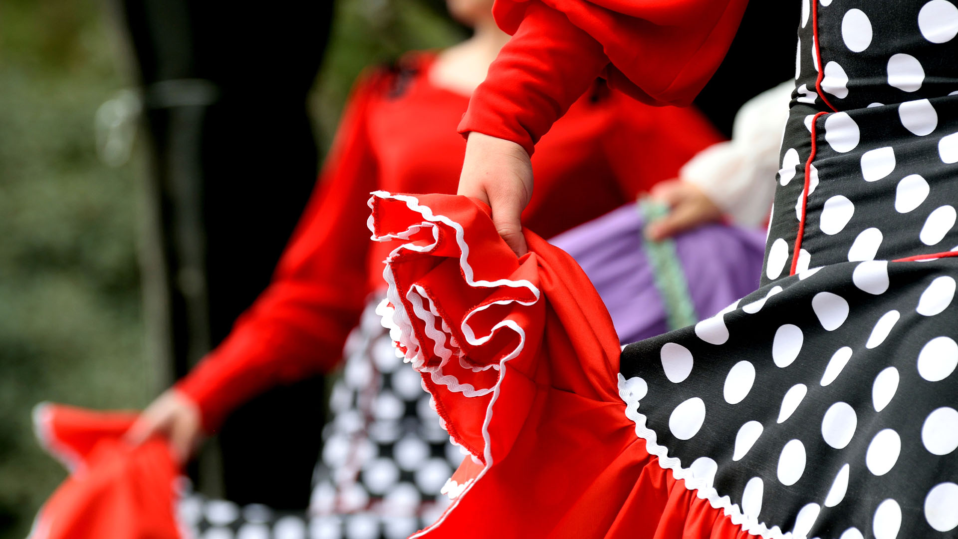 Dancers wearing vibrant flamenco dresses