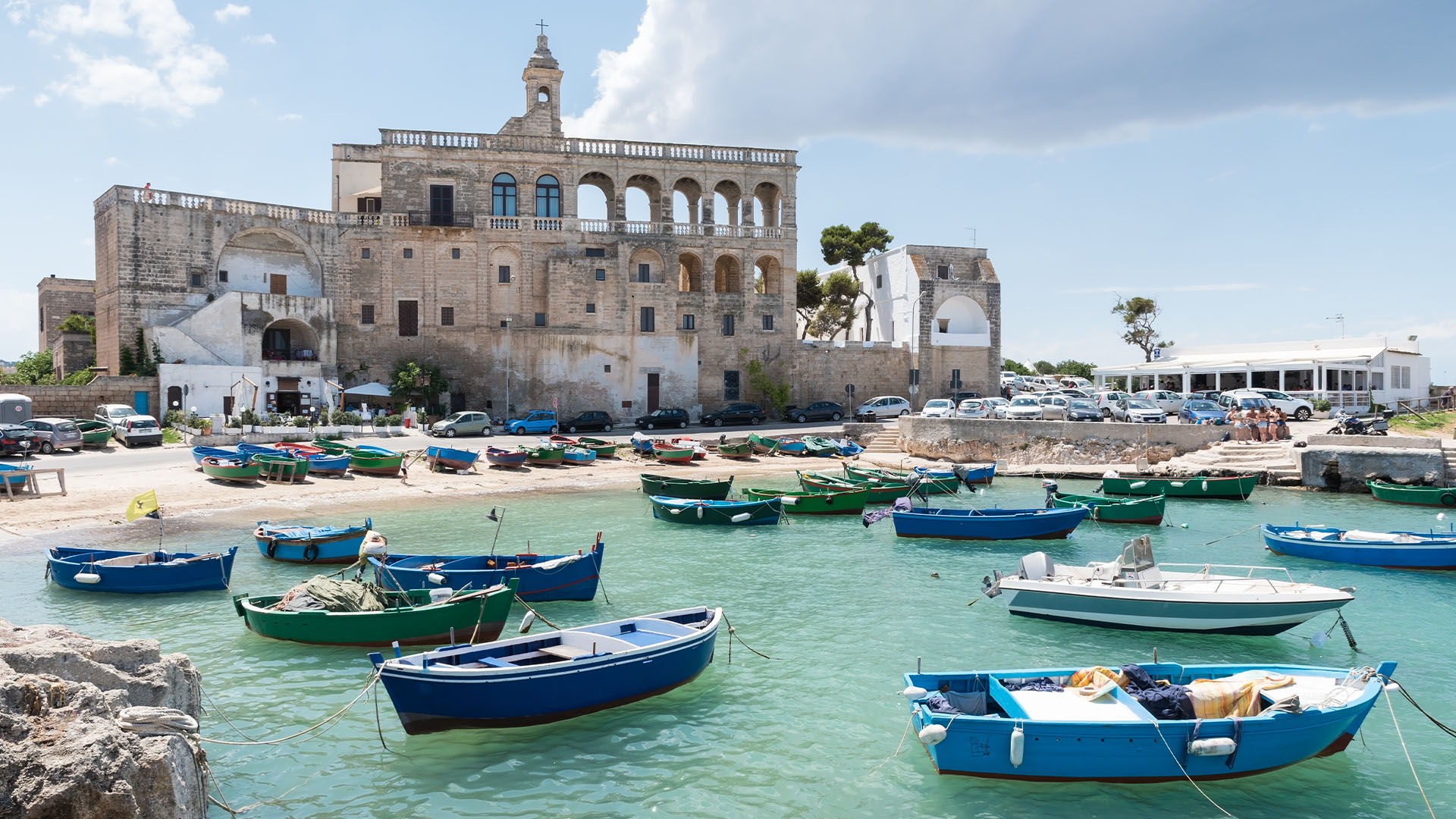 Small wooden fishing boats moored near an old abbey