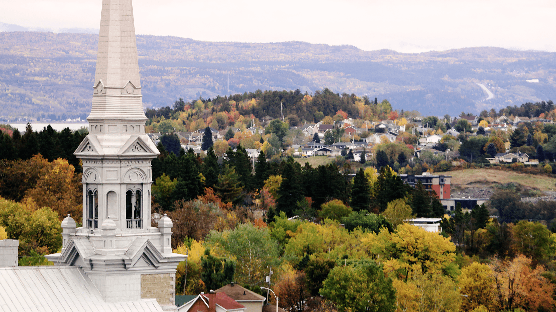 Church steeple overlooking rolling hills in Québec