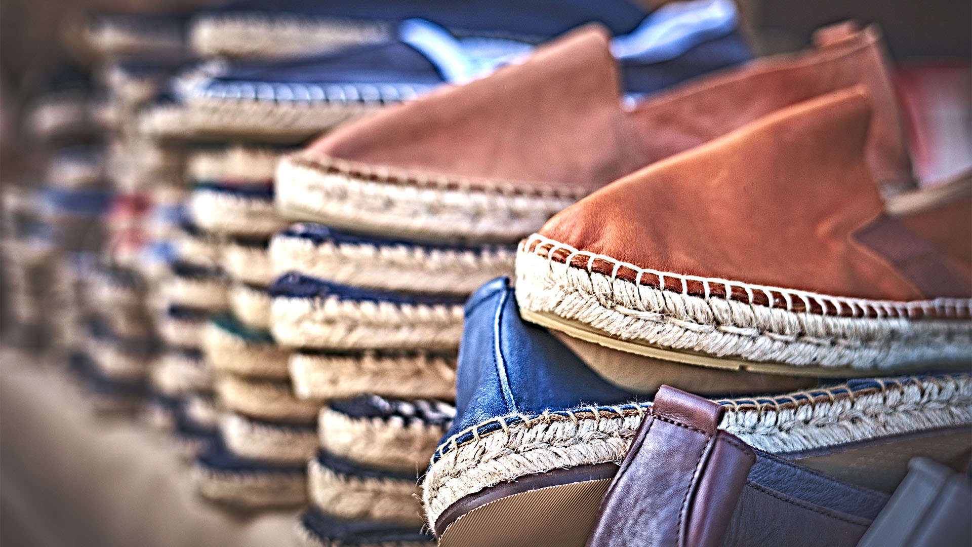Hand-stitched leather slippers in piles on a shelf