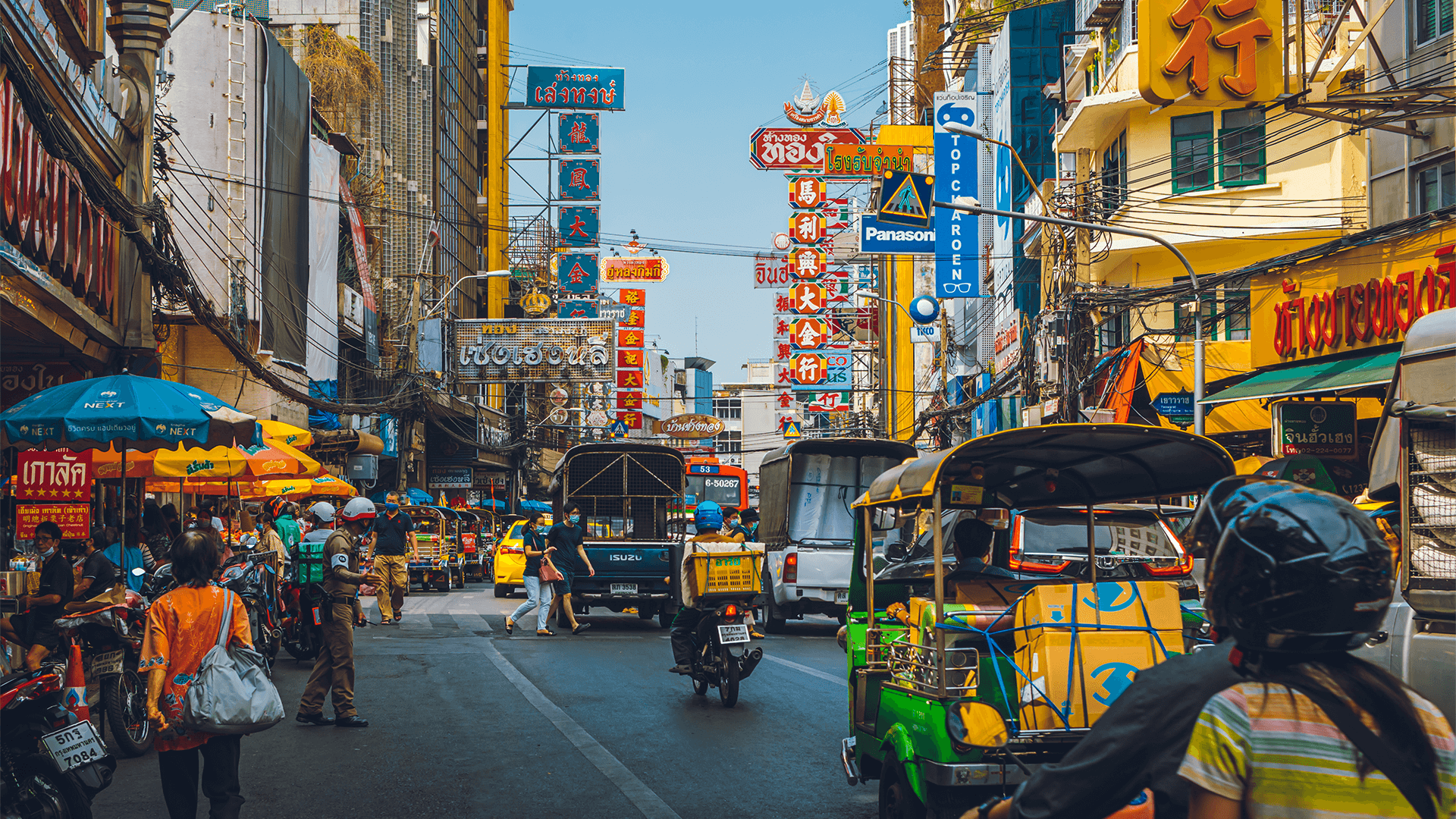   Busy Bangkok street with tuk-tuks and neon signs