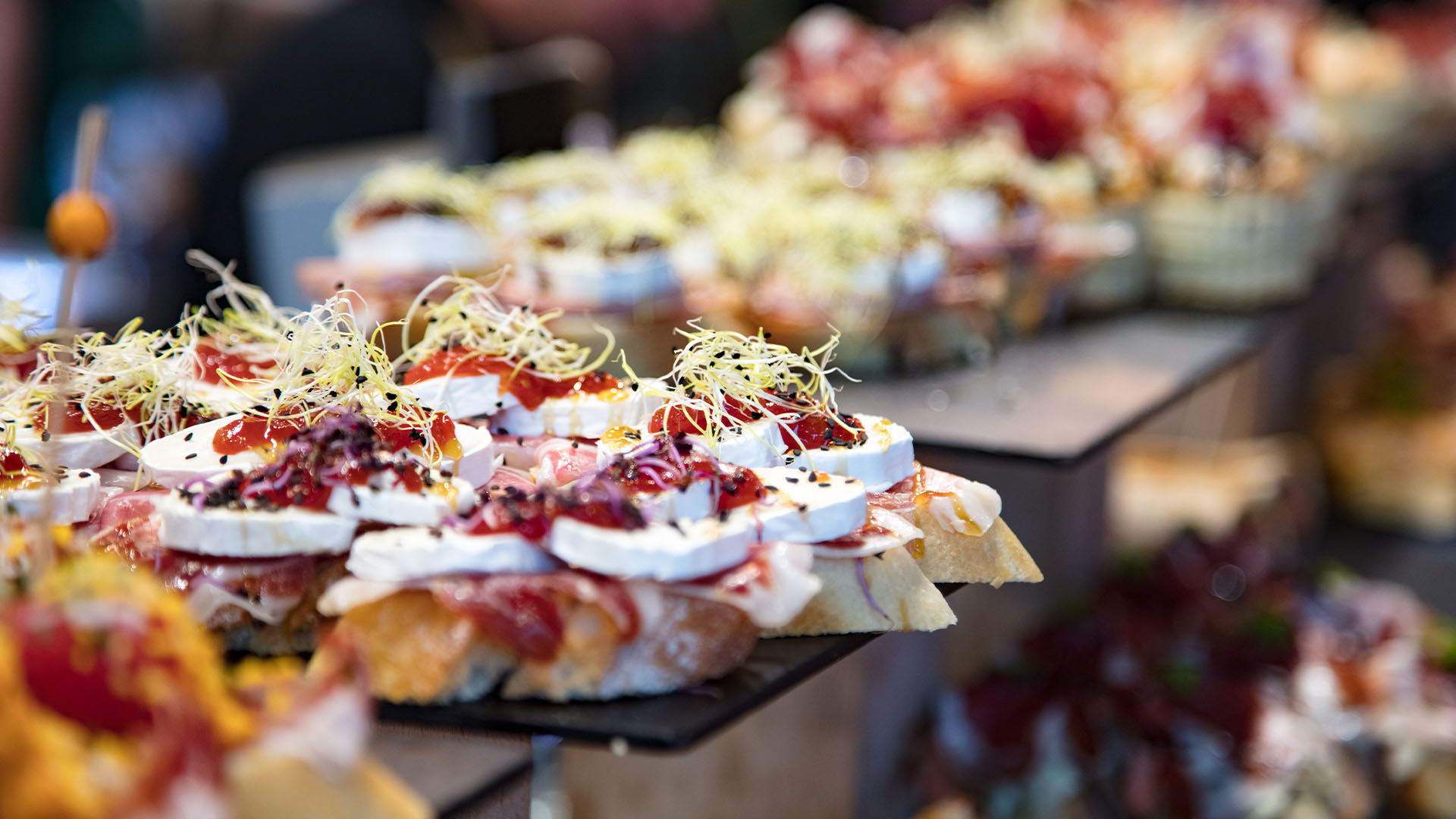 Close-up of pintxos stacked on plates at a bar counter